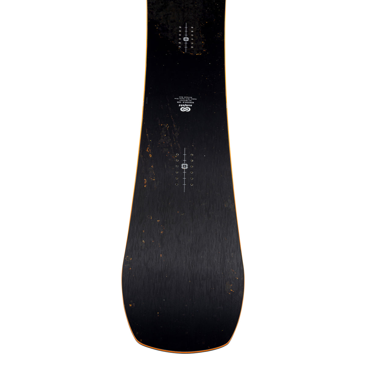 A close-up, top-down view of a snowboard's top, showing a dark black rust grain finish with subtle orange edge detailing and white printed graphics.