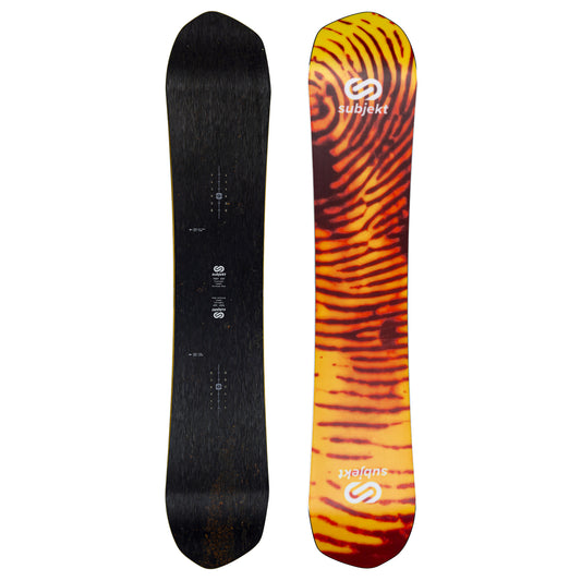 The top and base of a snowboard shown upright against a plain white background, displaying the topsheet and base views. The left board is solid black with subtle wood grain, and the right board features a bold orange, yellow, and black tiger-stripe pattern with white Subjekt branding.